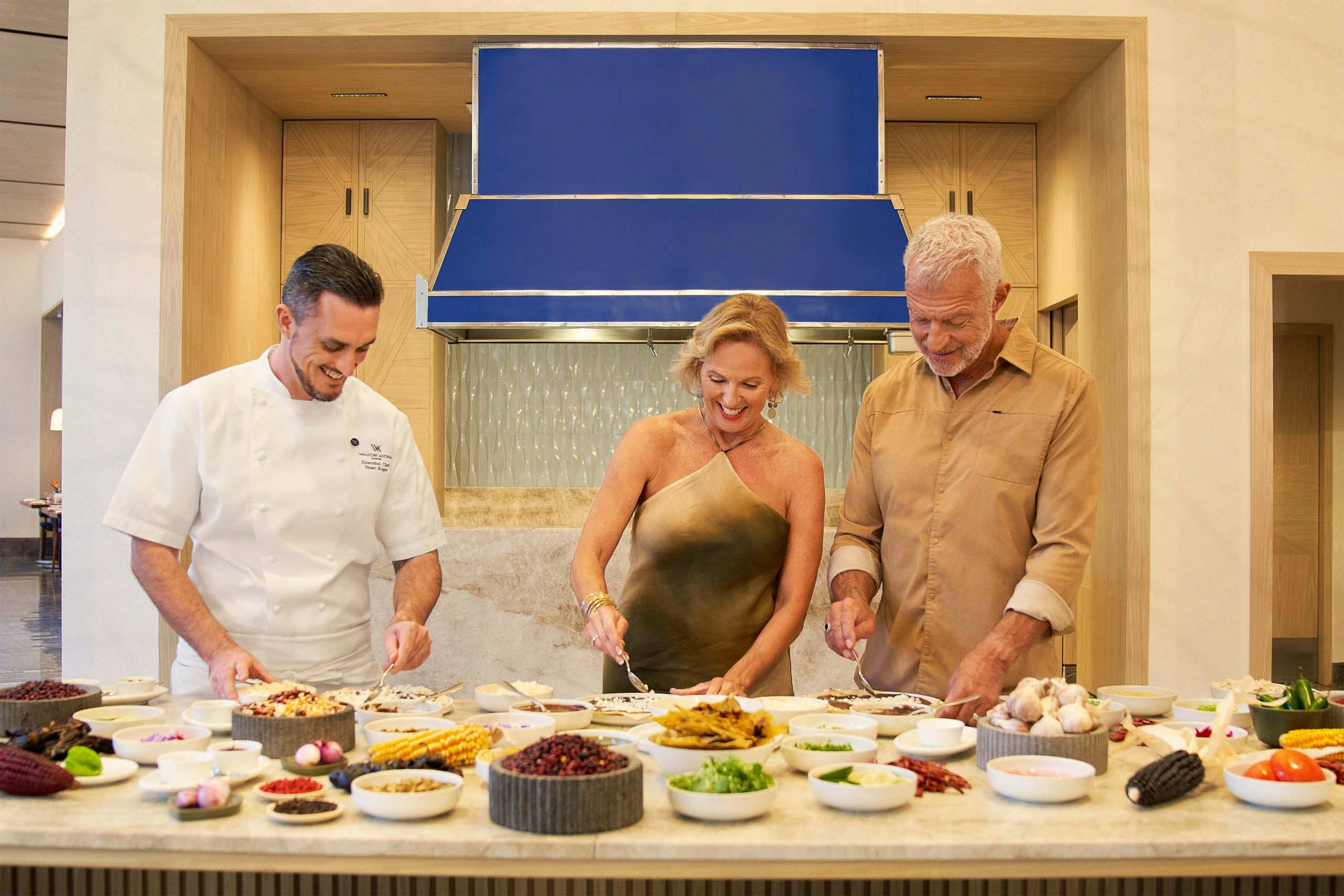Three people pick the delicious breakfast beautifully and elegantly presented on the table.