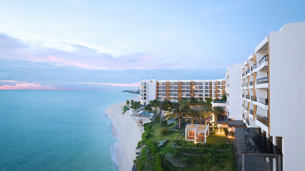 Aerial view of the resort's beachfront towers and turquoise Caribbean water at dusk