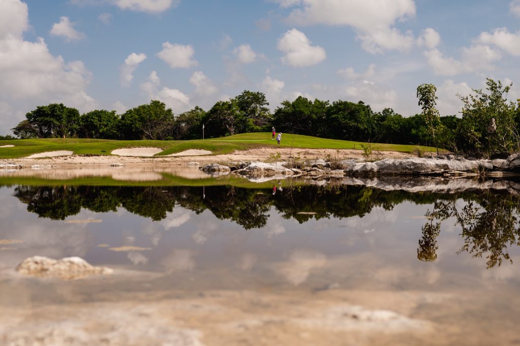 Aerial photo showcasing a lake surrounded by vibrant, lush green landscape beauty.