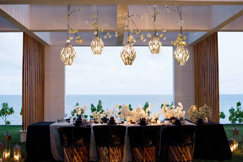 Una mesa de comedor totalmente decorada ofrece una maravillosa vista del océano, mezclando la elegancia con la belleza natural.