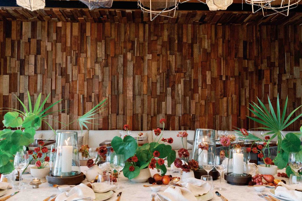 Una mesa de comedor totalmente decorada con pequeños jarrones y vajilla, lista para la celebración.