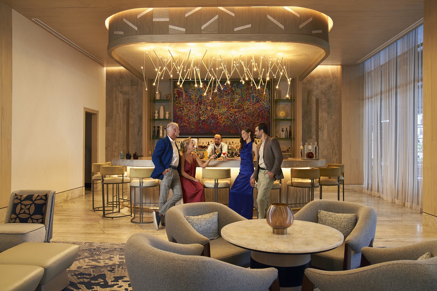 Two couples talk at the bar counter while the bartender watches them quietly.