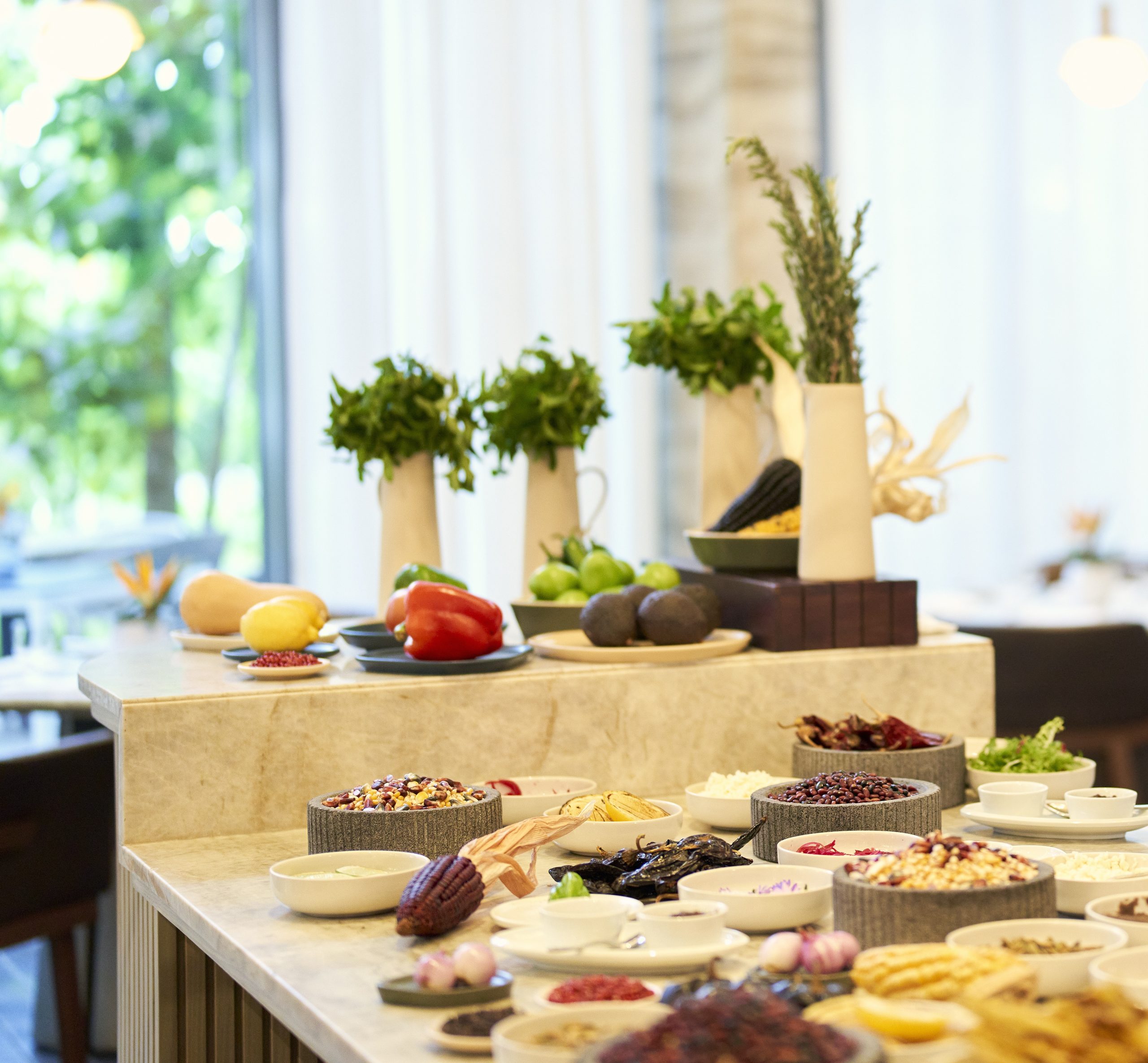 Various delicious meals are arranged on the table alongside small decorative flower vases.