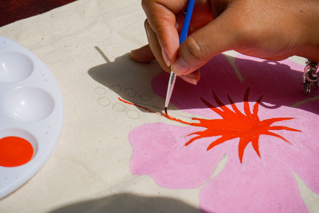 A hand gracefully adds the final, beautiful touch to a nearly finished painting.